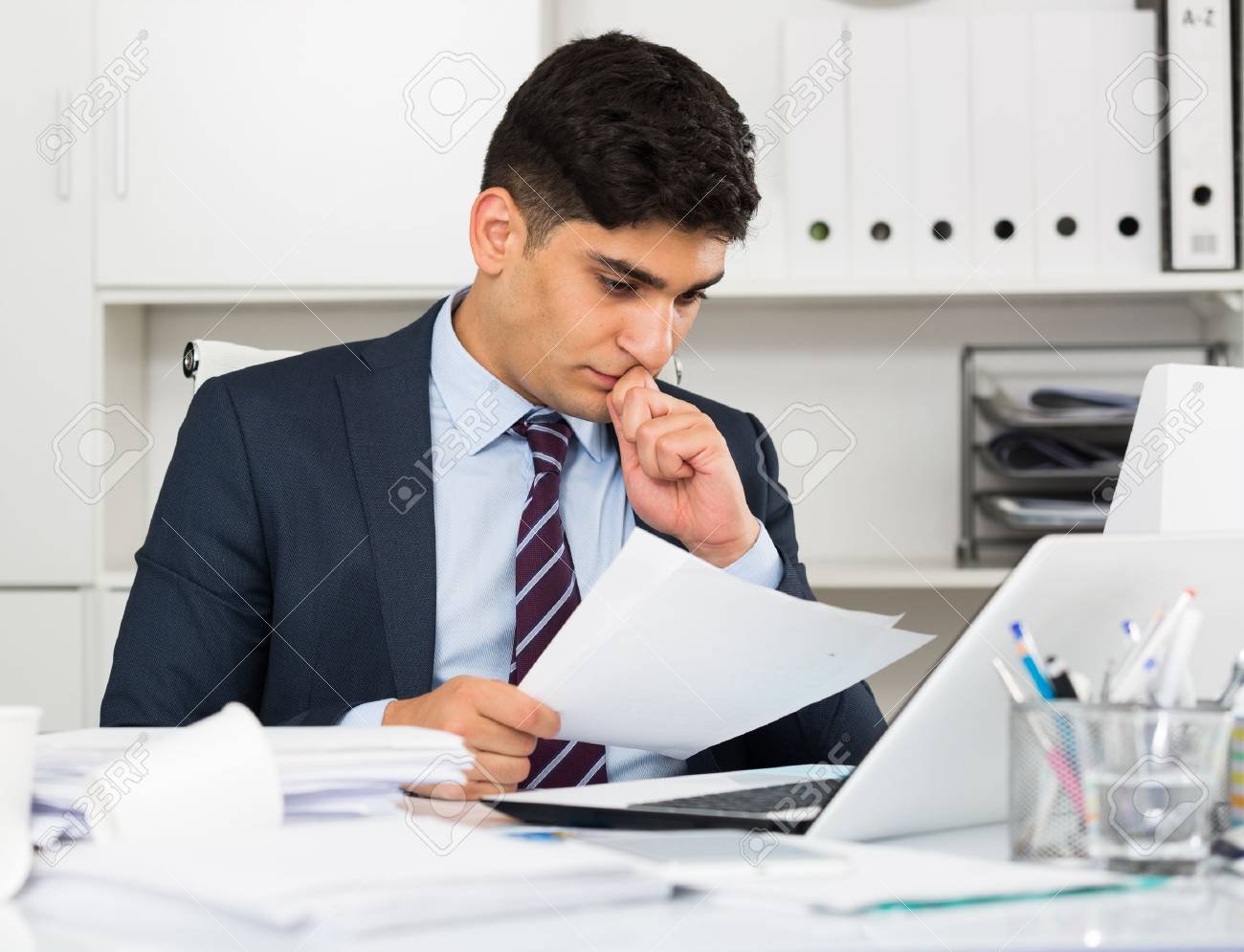 87285406 el profesional masculino esta leyendo documentos sobre la transaccion en la oficina