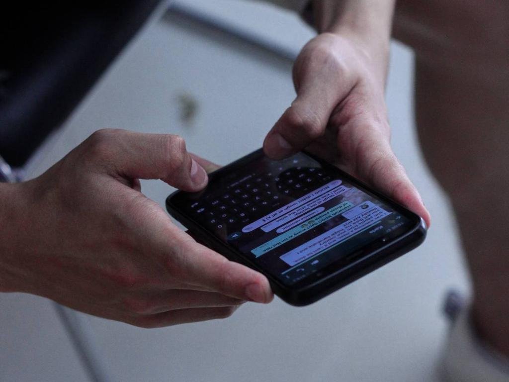 mano sosteniendo telefono con whatsapp abierto