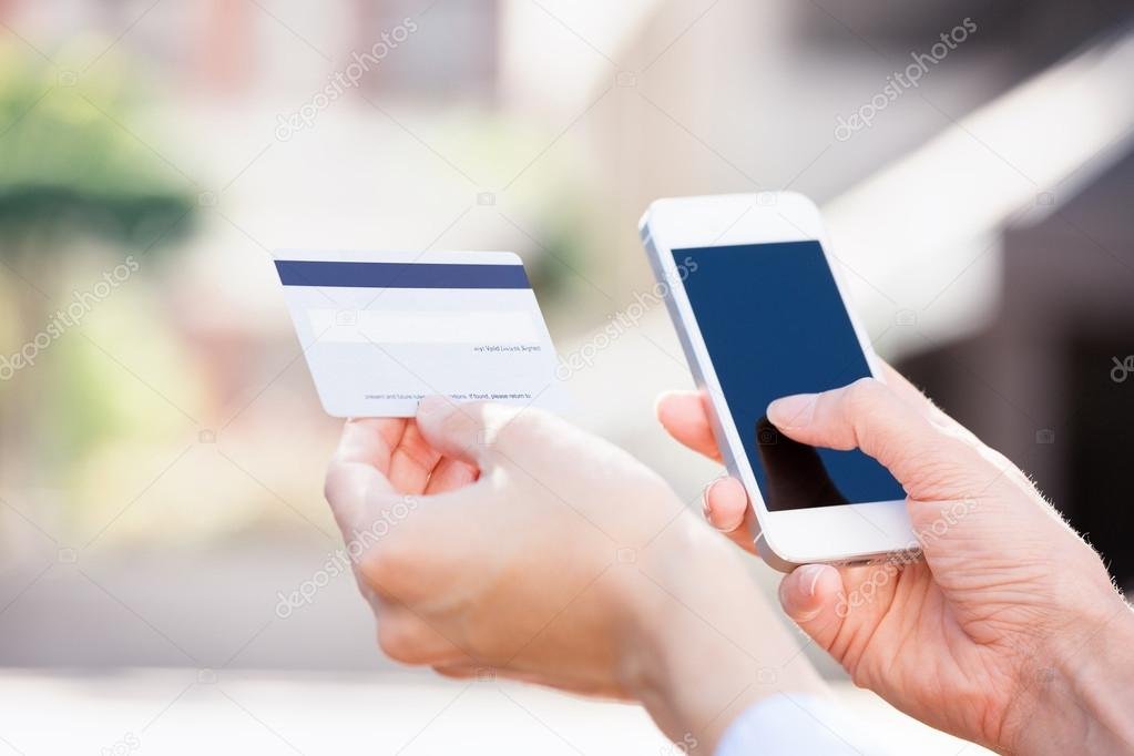 manos sosteniendo tarjeta de credito y celular