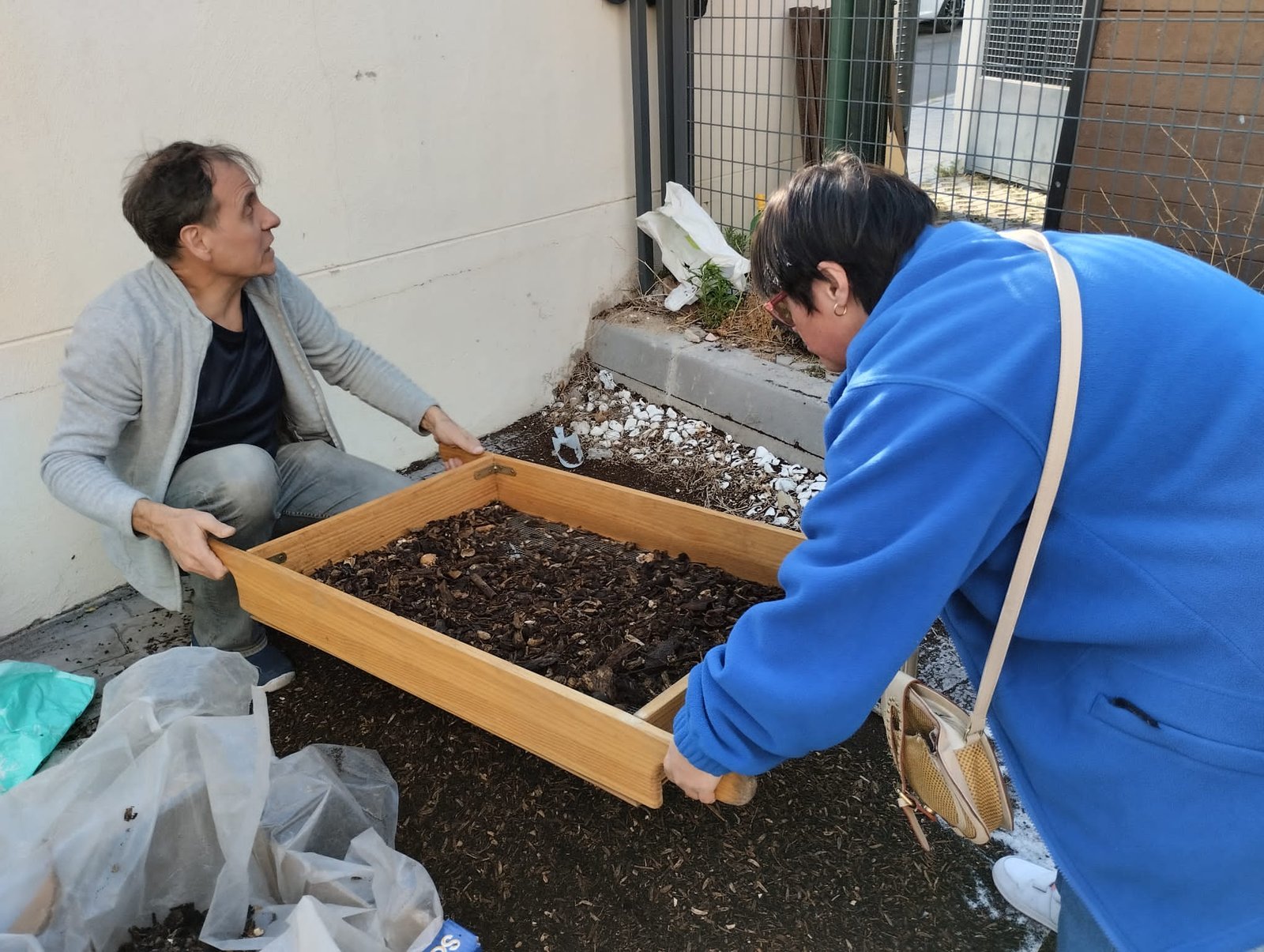 ninos compostando con alegria en el jardin