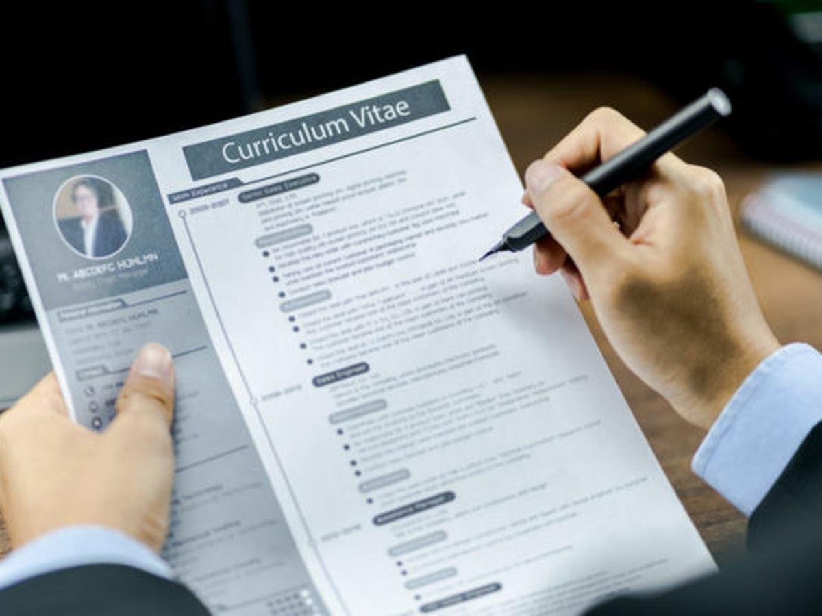 persona escribiendo en un curriculum vitae